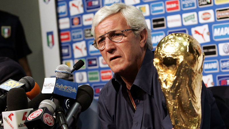Italian national soccer team coach Marcello Lippi looks on next to the soccer World Cup 2006 during a press conference, in Duisburg, Germany, Monday, July 10, 2006. Italy won the soccer World Cup 2006 after defeating France in the final. (AP Photo/Andrew Medichini)